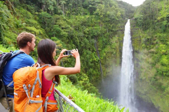 couple taking picture of Hawaii waterfall