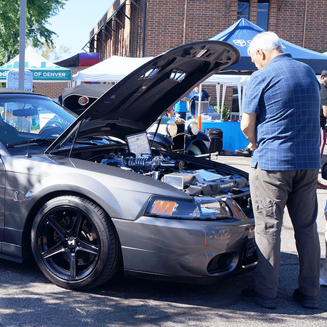 Person looking under the hood of a Ford Mustang