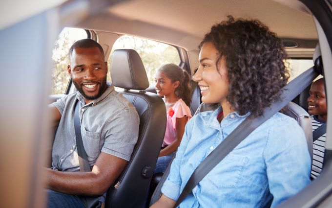 family driving in car on road trip