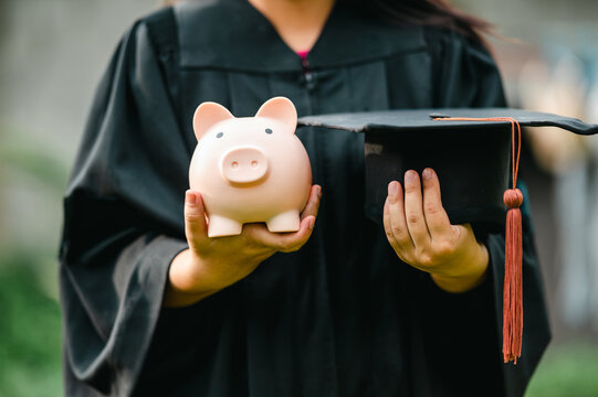Recent grad holds piggy bank