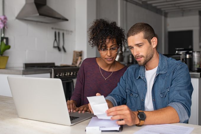 multiethnic couple looks over bills