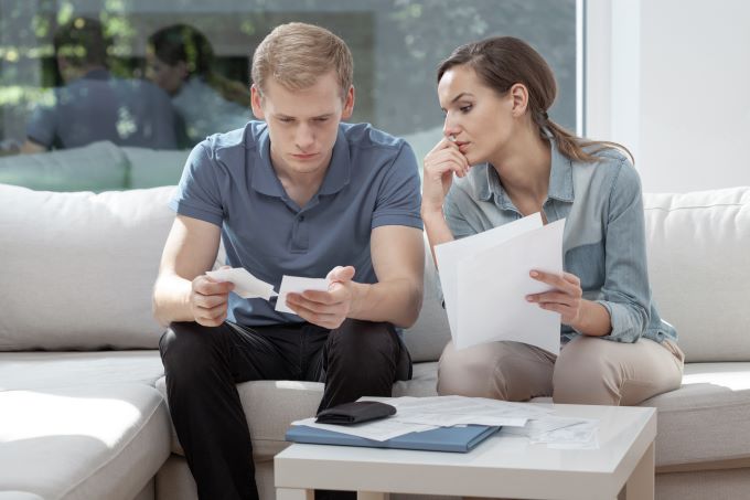 stressed couple looking at bills