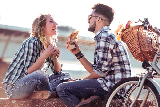 young couple eating sandwiches